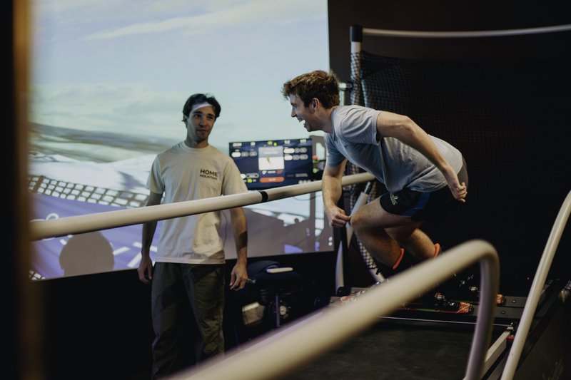 Two people training together on the SkyTechSport ski simulator at Home Mountain in Los Angeles